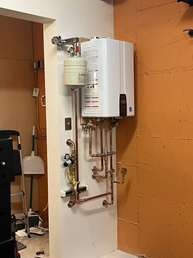 Plumbing technician inspecting water heater connections in Violet